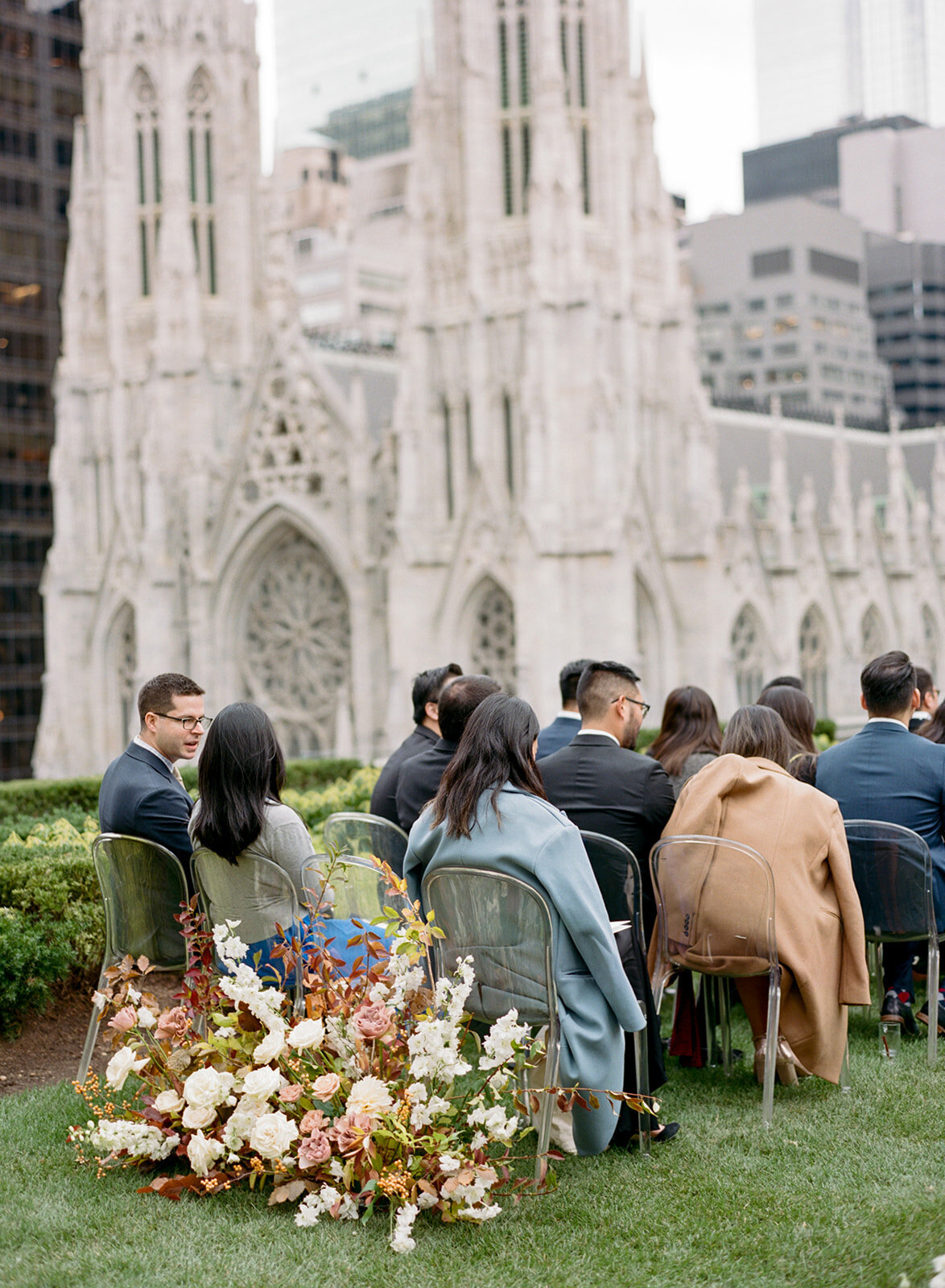 Floral growing garden behind guests chairs at wedding ceremony