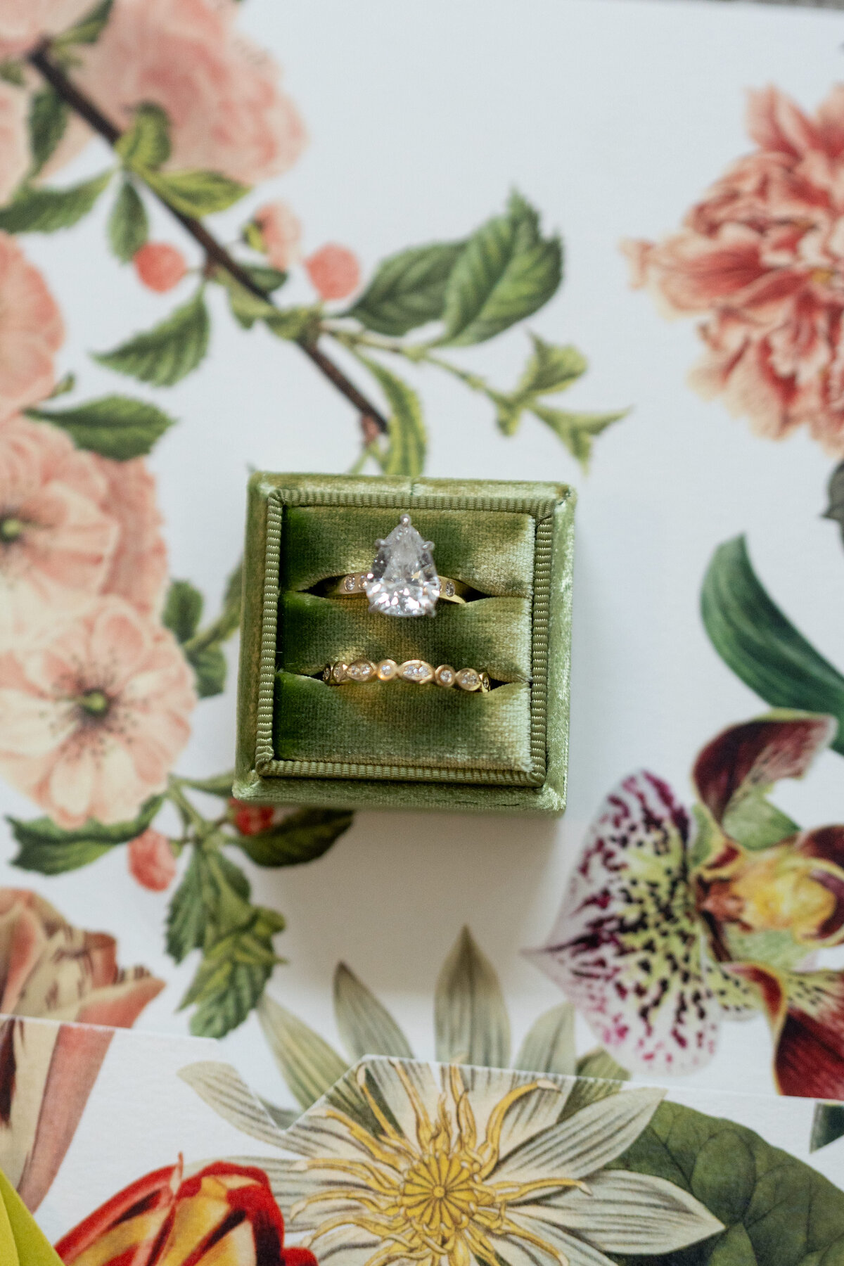 Pear wedding ring, sitting on a floral invitation