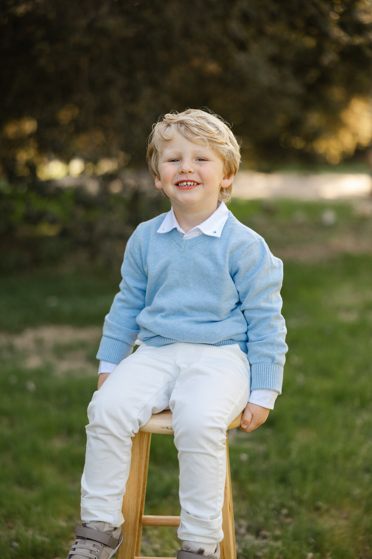 Little boy sitting on a stool in light blue sweater and white pants. Photographed by Yucaipa family photographer Kaitlyn Dawn Photography.