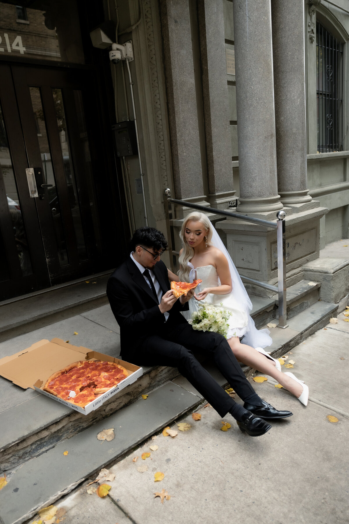The couple having a playful pizza night in NYC to celebrate their intimate elopement.