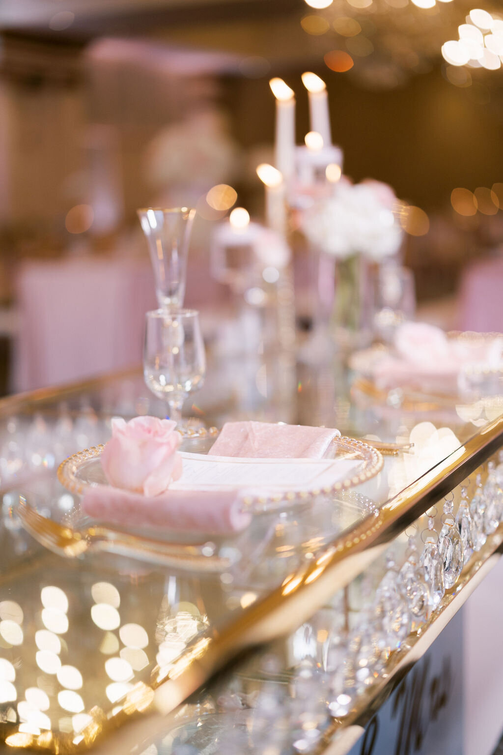 glass table with gold accents and pink, gold, and glass decor