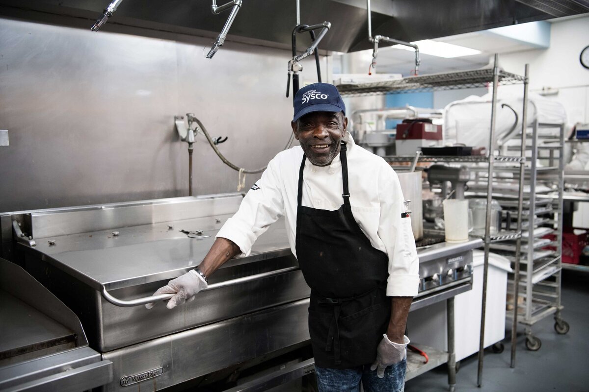 An environmental portrait of a worker in a kitchen