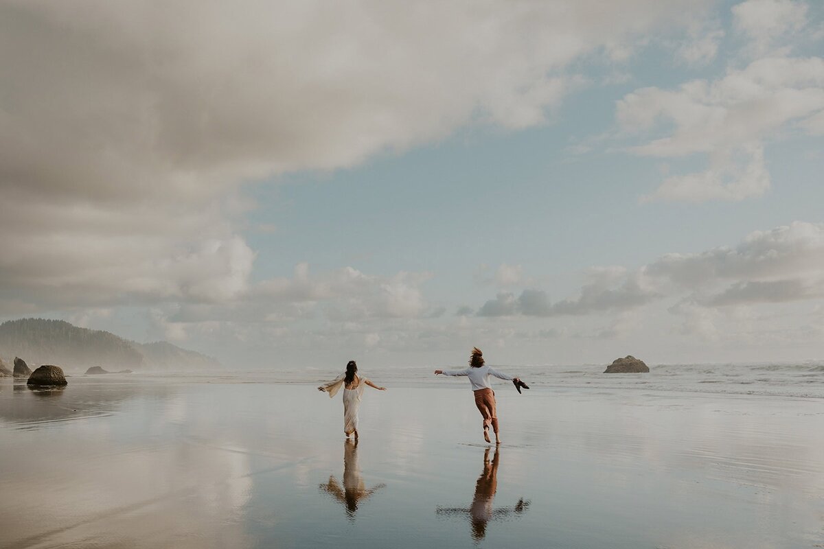 A couple running on the beach during their elopement on the Oregon Coast