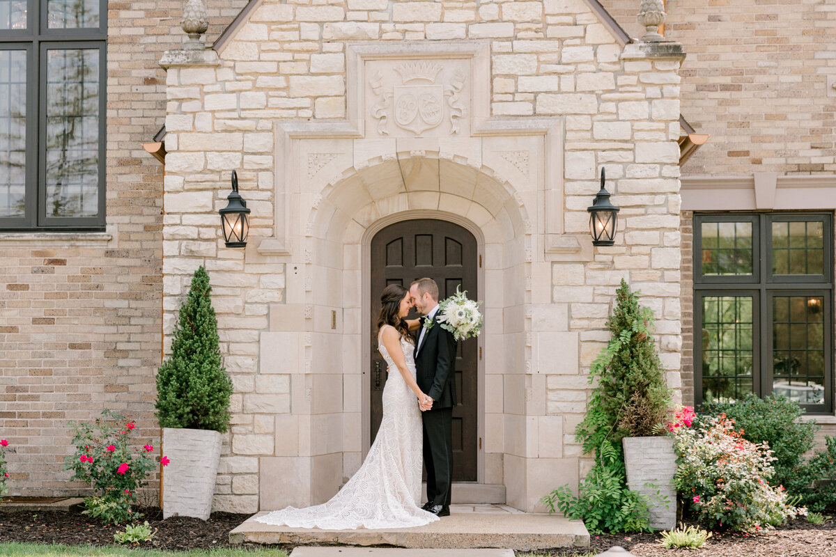 bride and groom in front of brick building