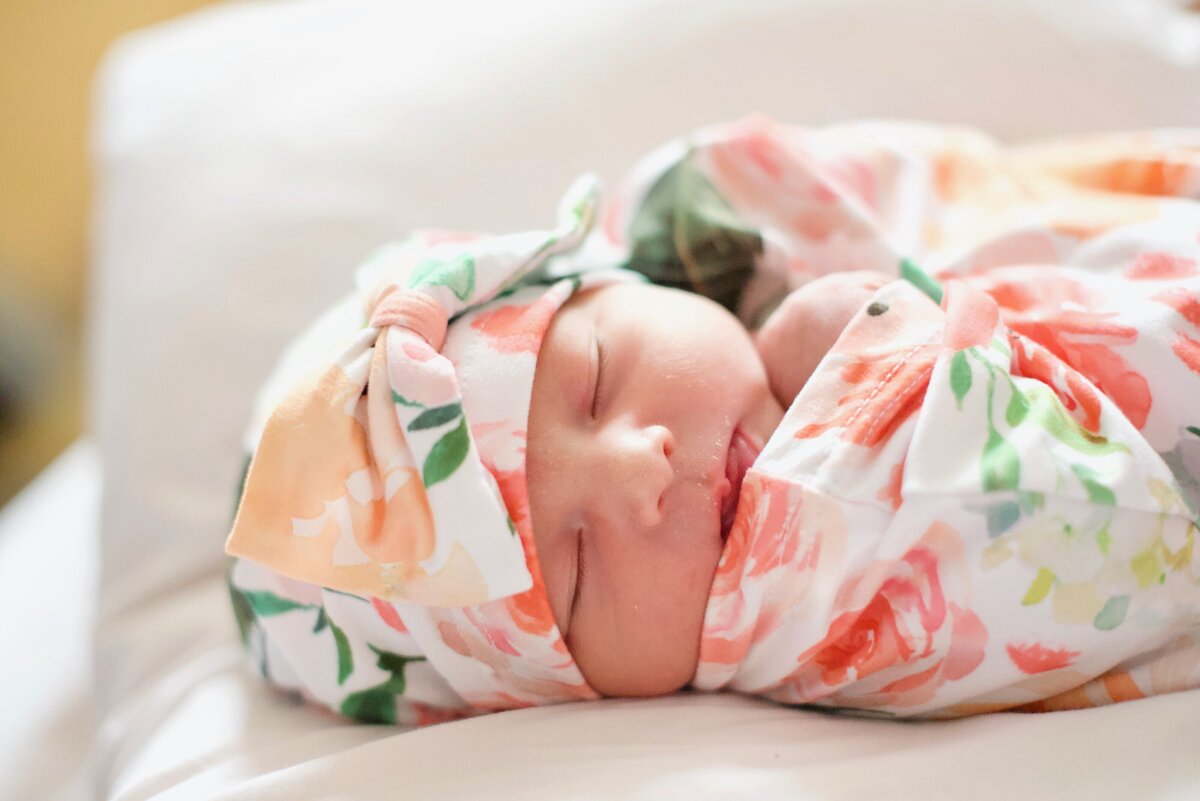 newborn girl in a floral blanket