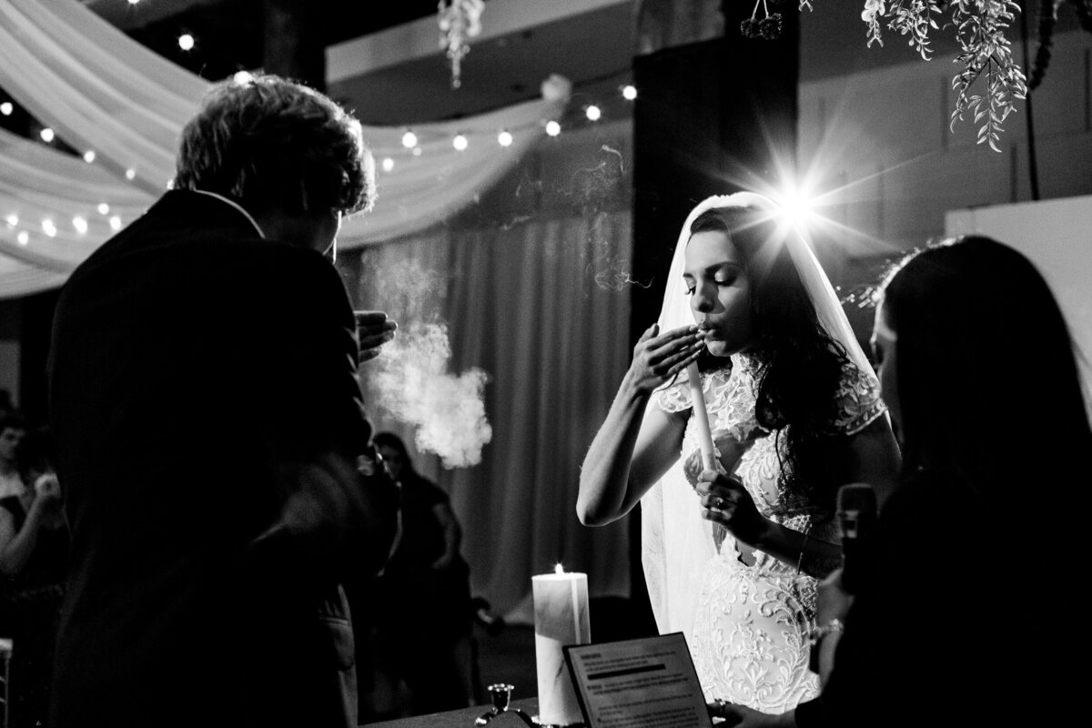 One of the top wedding photos of 2020. Taken by Adore Wedding Photography- Toledo, Ohio Wedding Photographers. This photo is of bride and groom blowing out their candles during the unity ceremony at Registry Bistro in Toledo Ohio