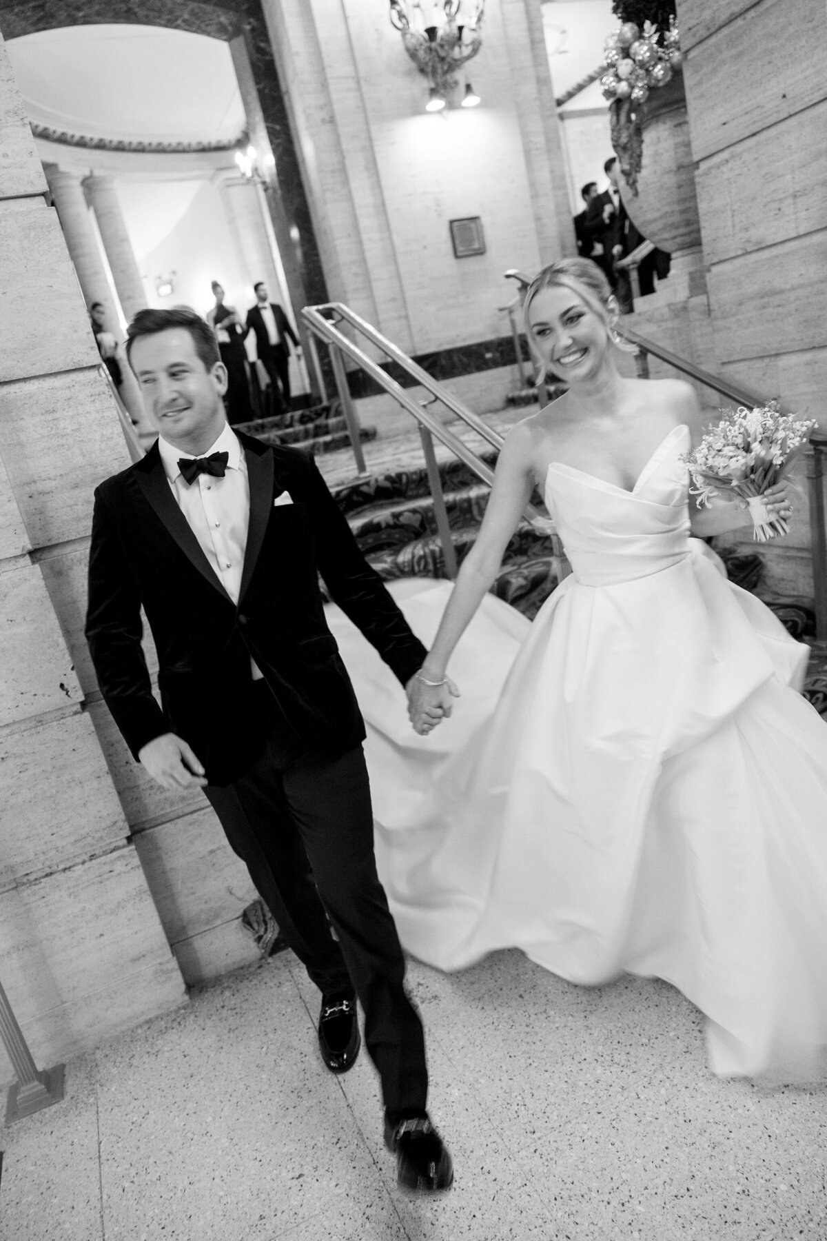 The bridge and groom hold hands at the wedding reception in the Palmer House Chicago.