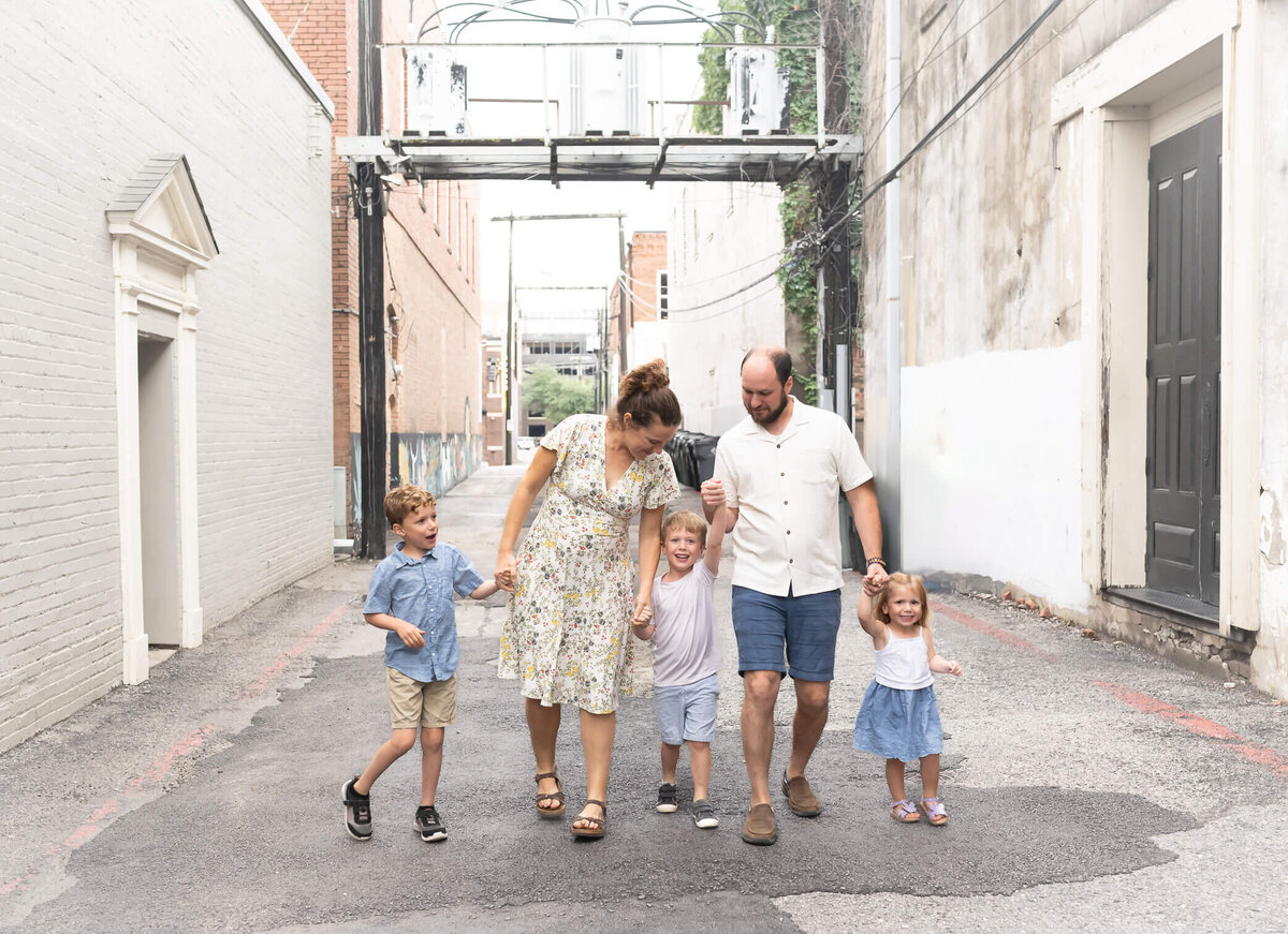 adorable family walking through an alley way holding hands