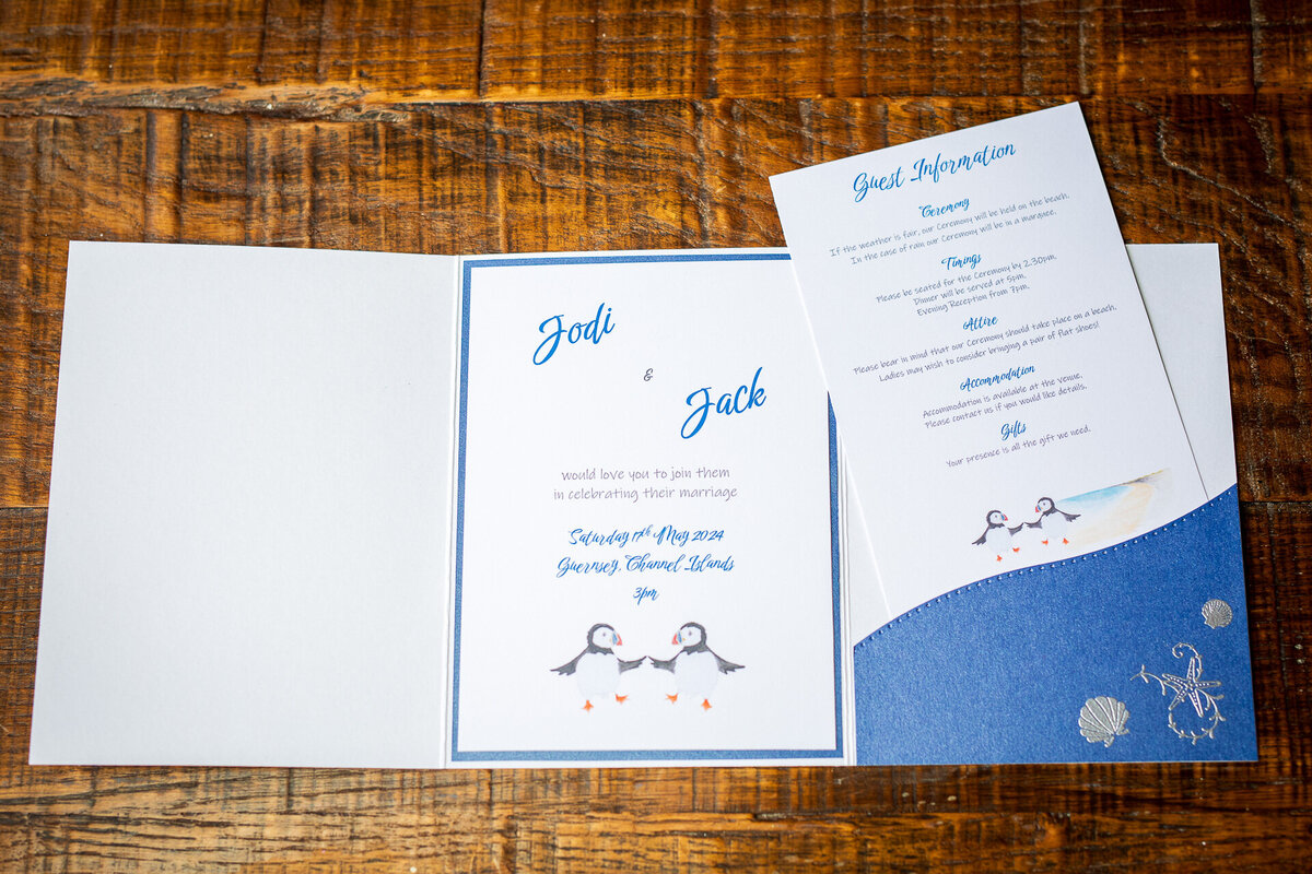 Nautical wedding invtation featuring puffins and embossed shells