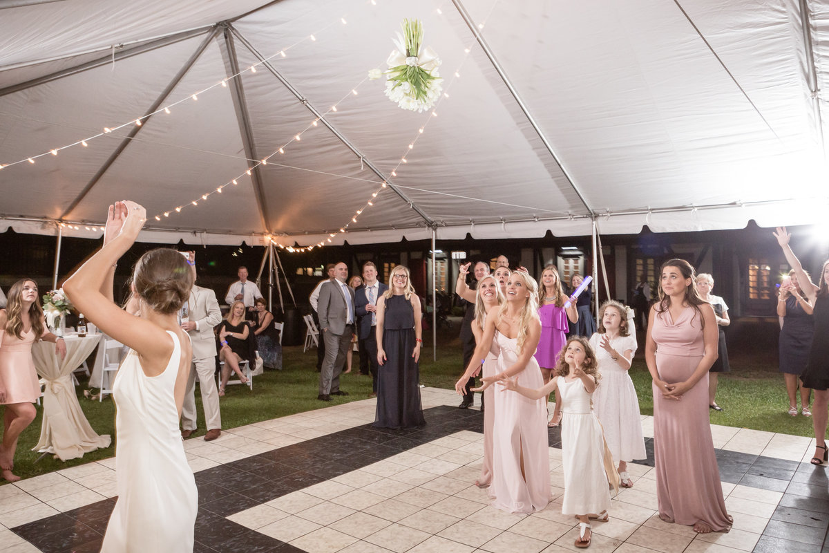 The bride tosses her bouquet to the single girls at her wedding reception at Ft. Conde in Mobile, Alabama.