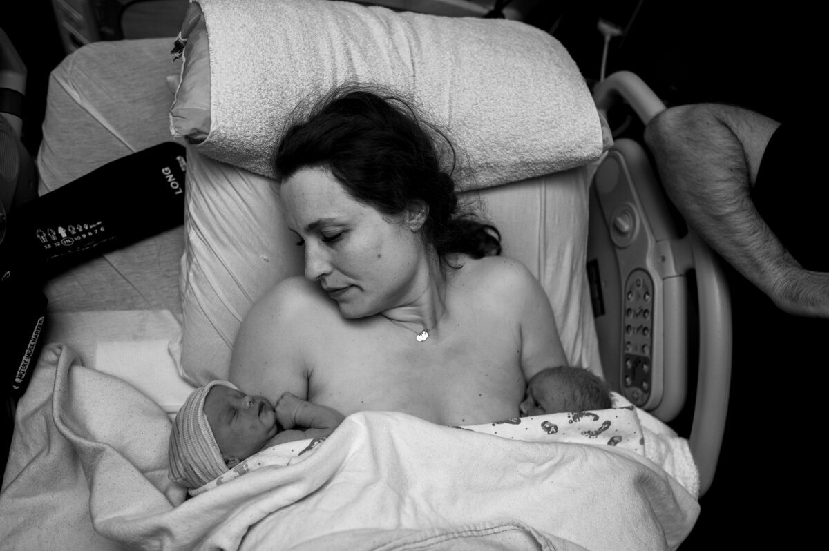 Twin birth mom receiving love from newborn babies. 