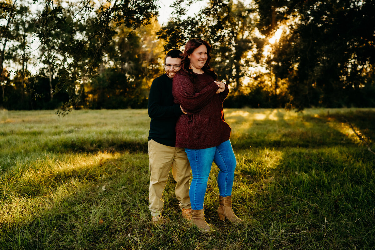 candid engagement photo of couple dancing at sunset in field in lafayette, la