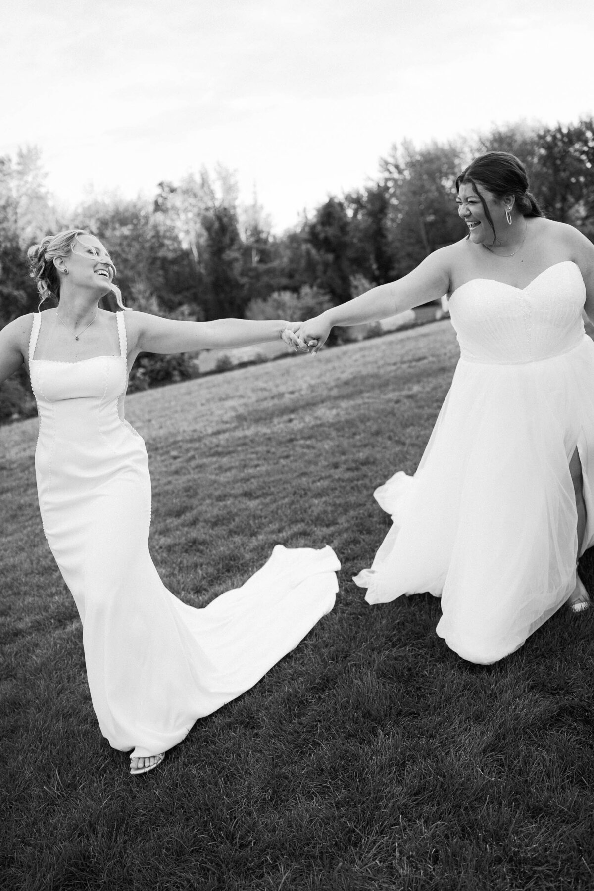 brides running through field taken by boston documentary wedding photographer