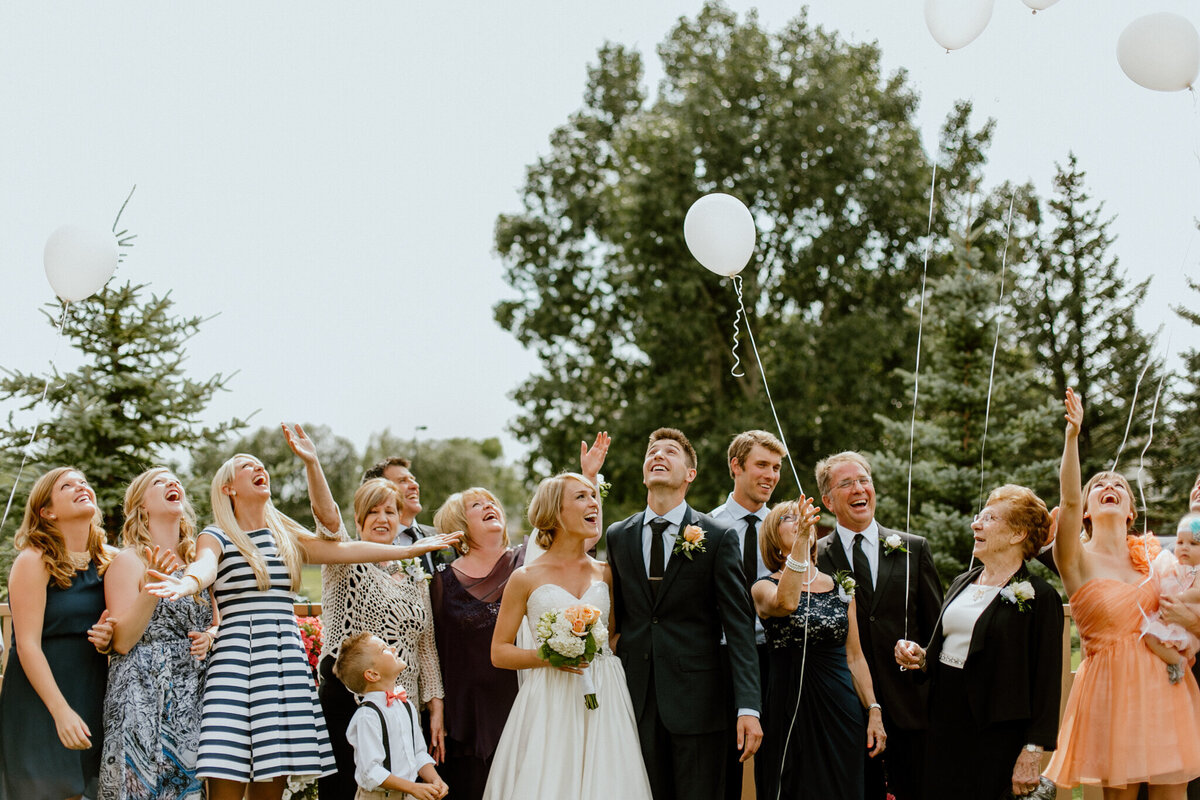 Fun and modern twist on wedding family portraits, couple  and family with balloons, captured by Love and be Loved Photography, authentic and natural wedding photographer and videographer in Lethbridge, Alberta. Featured on the Bronte Bride Vendor Guide.