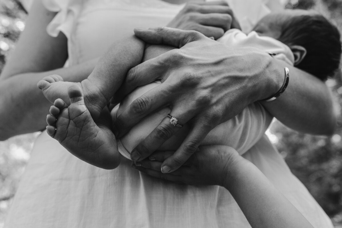 HOLDING NEWBORN OUTDOORS IN SUMMER