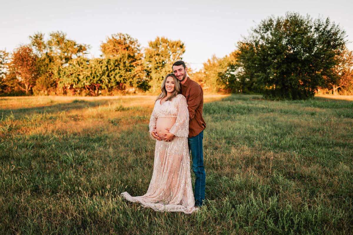 Springfield Mo maternity photographer Jessica Kennedy of The XO Photography of husband holding pregnant mom from behind holding baby bump