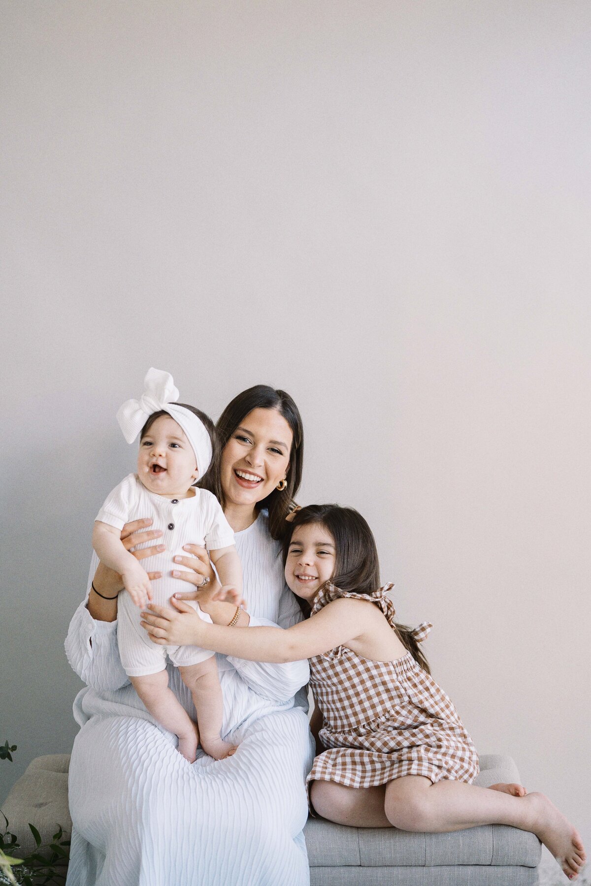 mom snuggling her two daughters