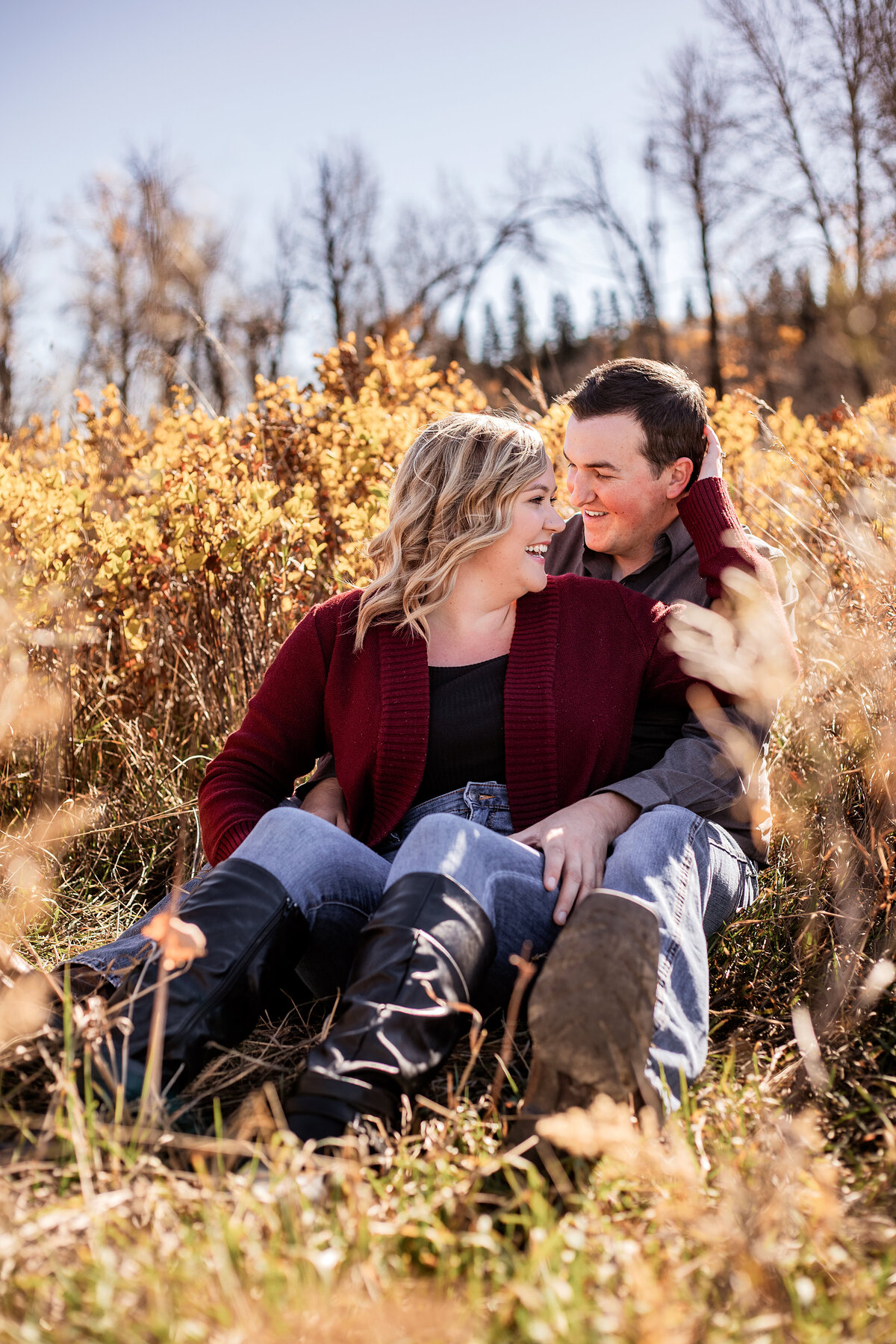 engaged-couple-sitting-in-field