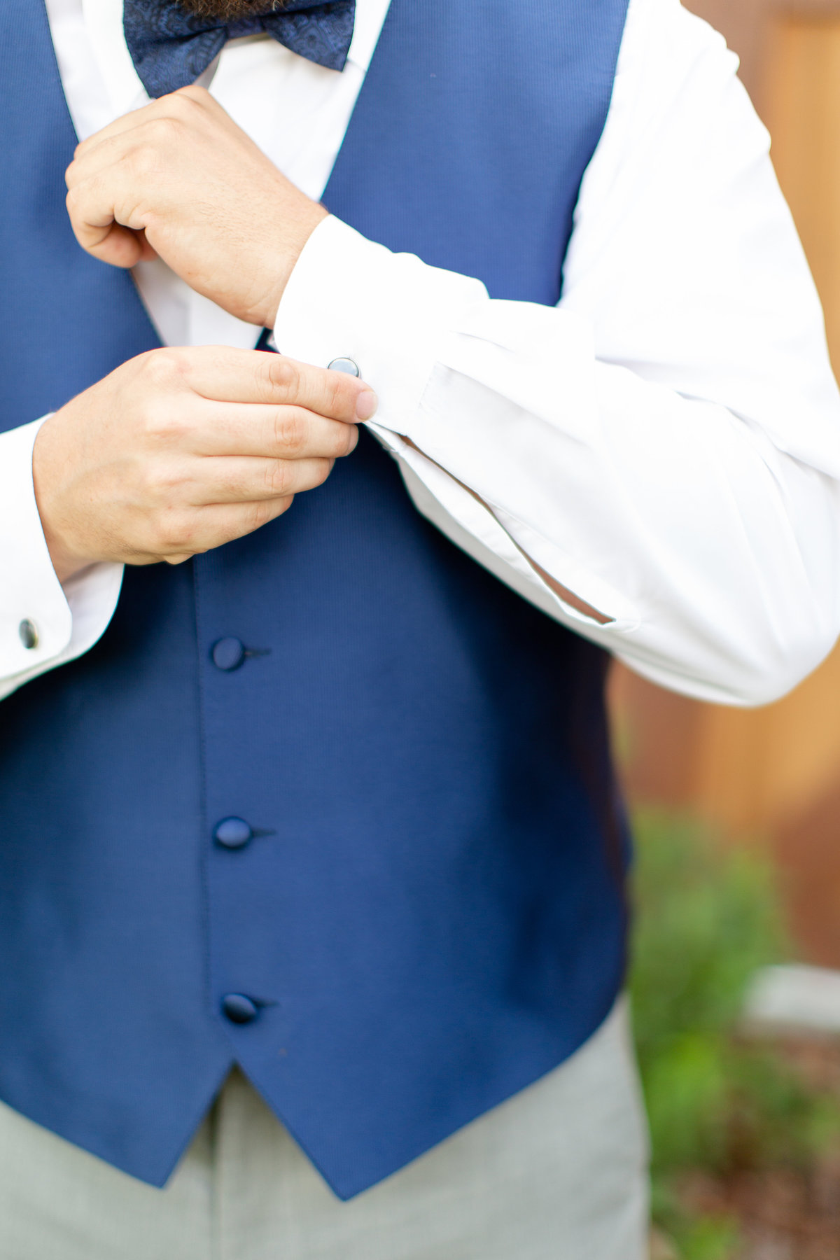 Groom in blue wedding day vest while he is getting ready for his wedding day in Lakeland, Florida