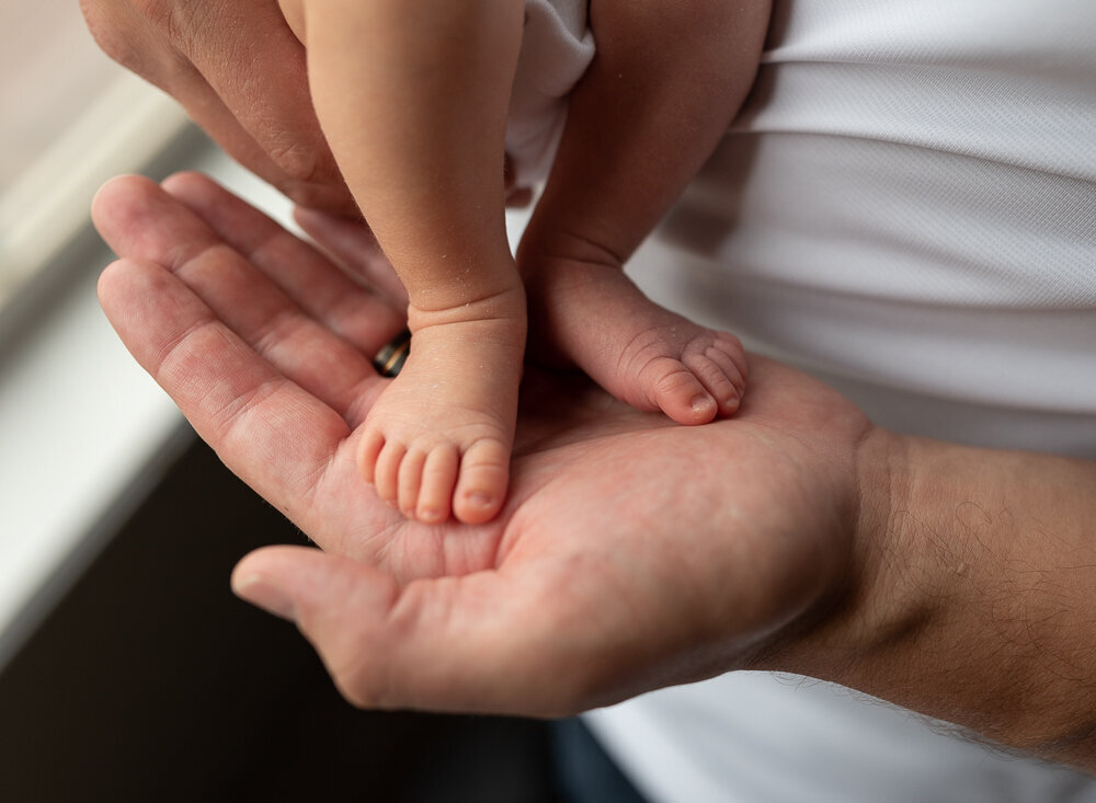 baby feet in dads hands