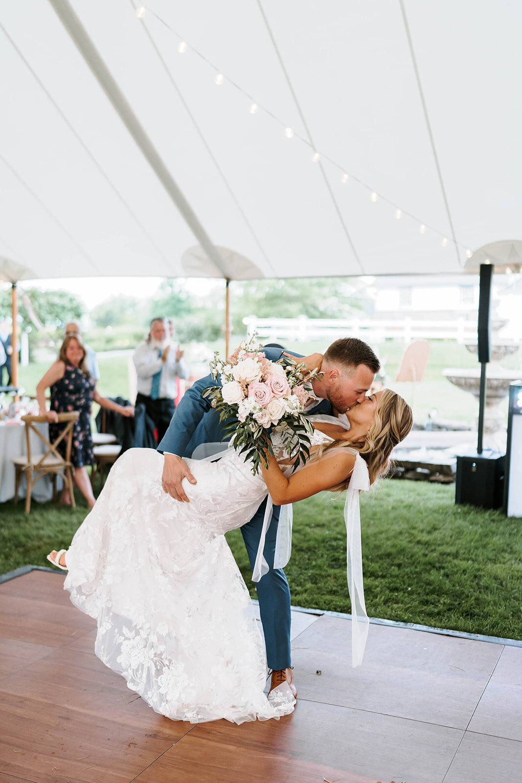 groom dipping bride for a kiss under tented wedding reception