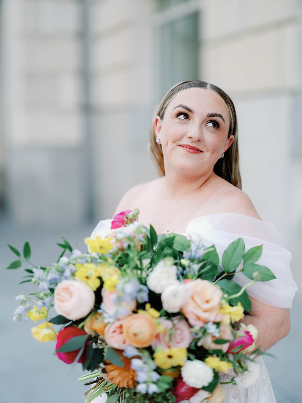 bride happily holding her colorful bouquet
