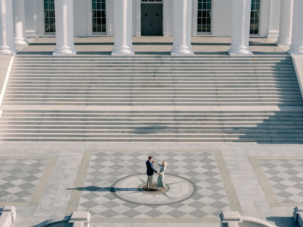 Virginia Capitol Building Engagement Session Richmond VA | drone photo of newly engaged couple dancing near the seal in front of the Virginia State Capitol Building in Richmond