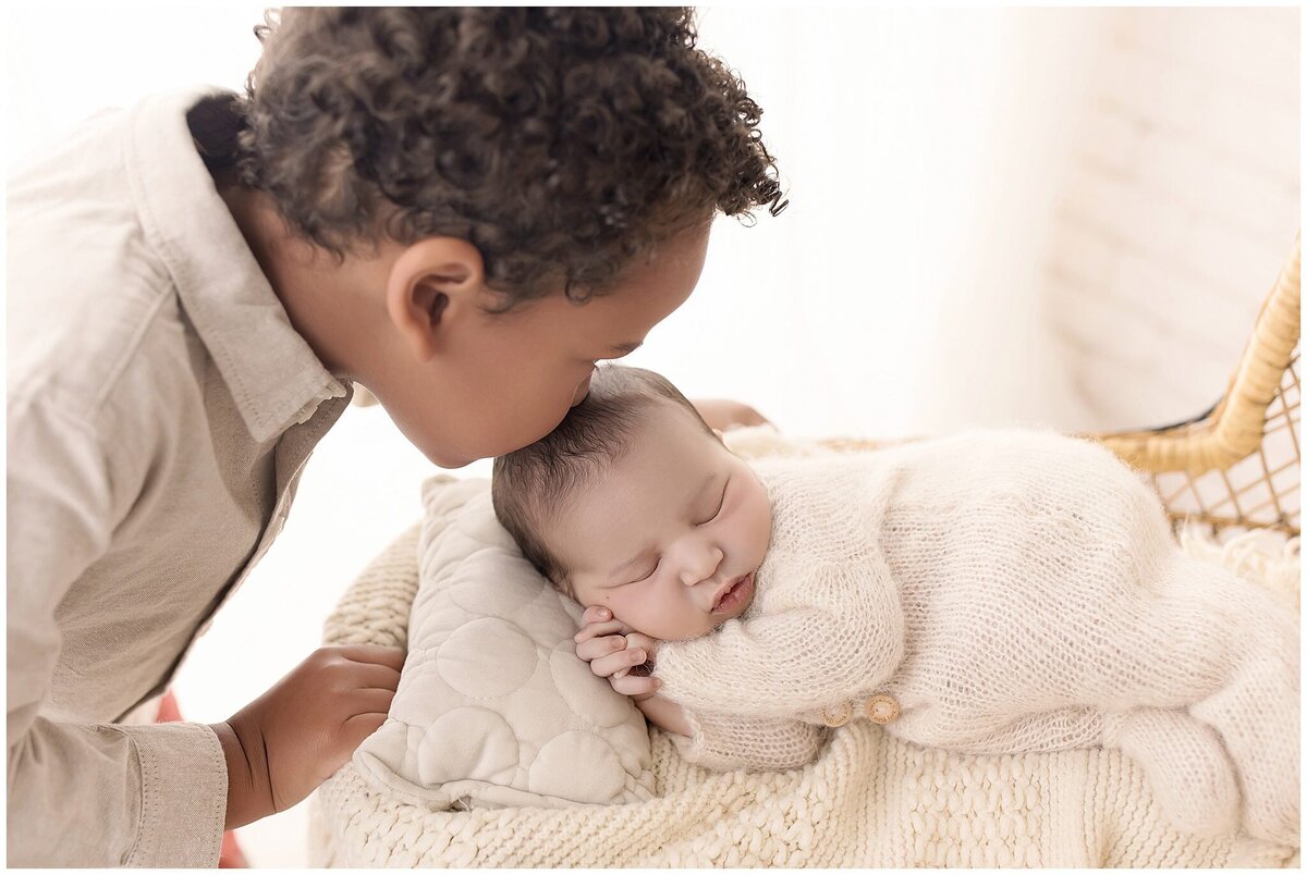 A sibling shows love to his newborn brother