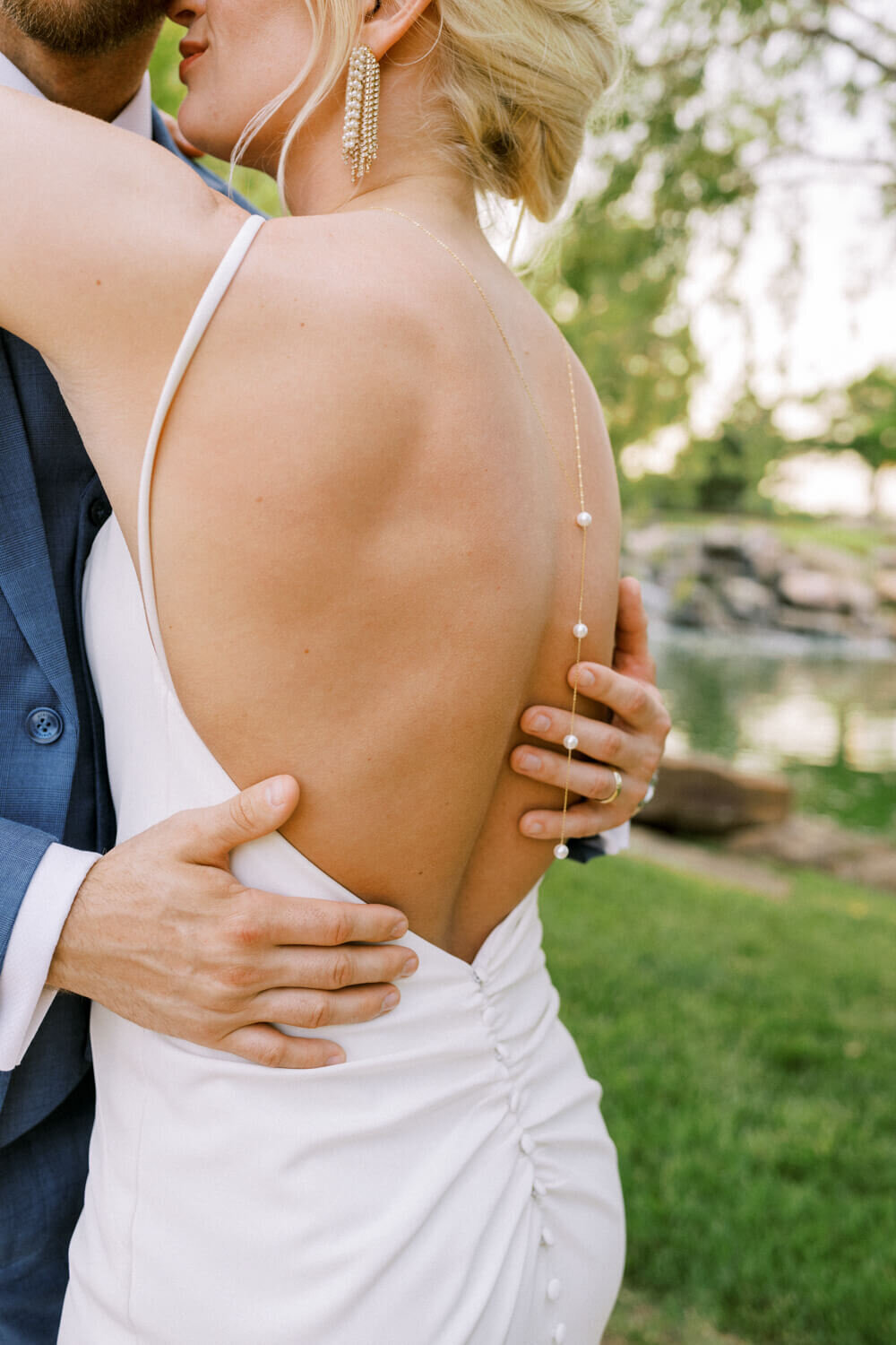 close-up-of-hands-on-back-with-pearl-necklace