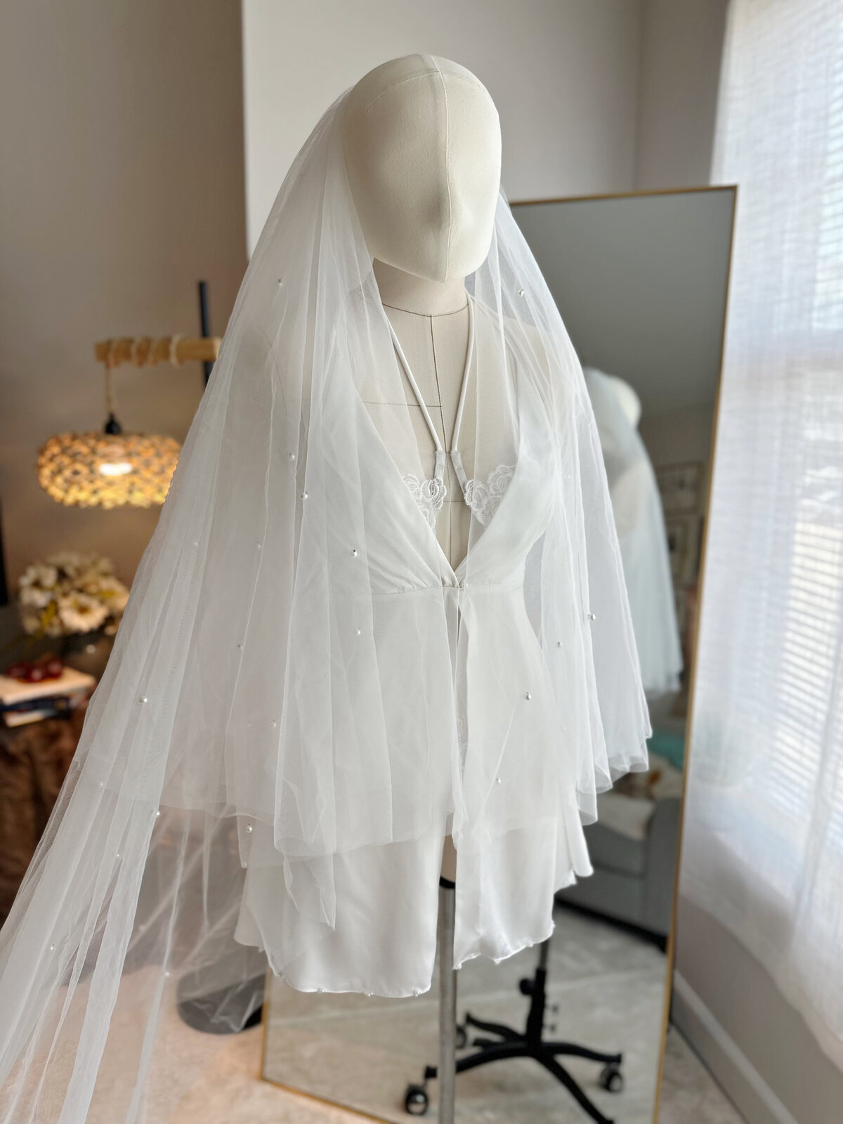 Bride styled in handmade lace blusher veil under sunlight
