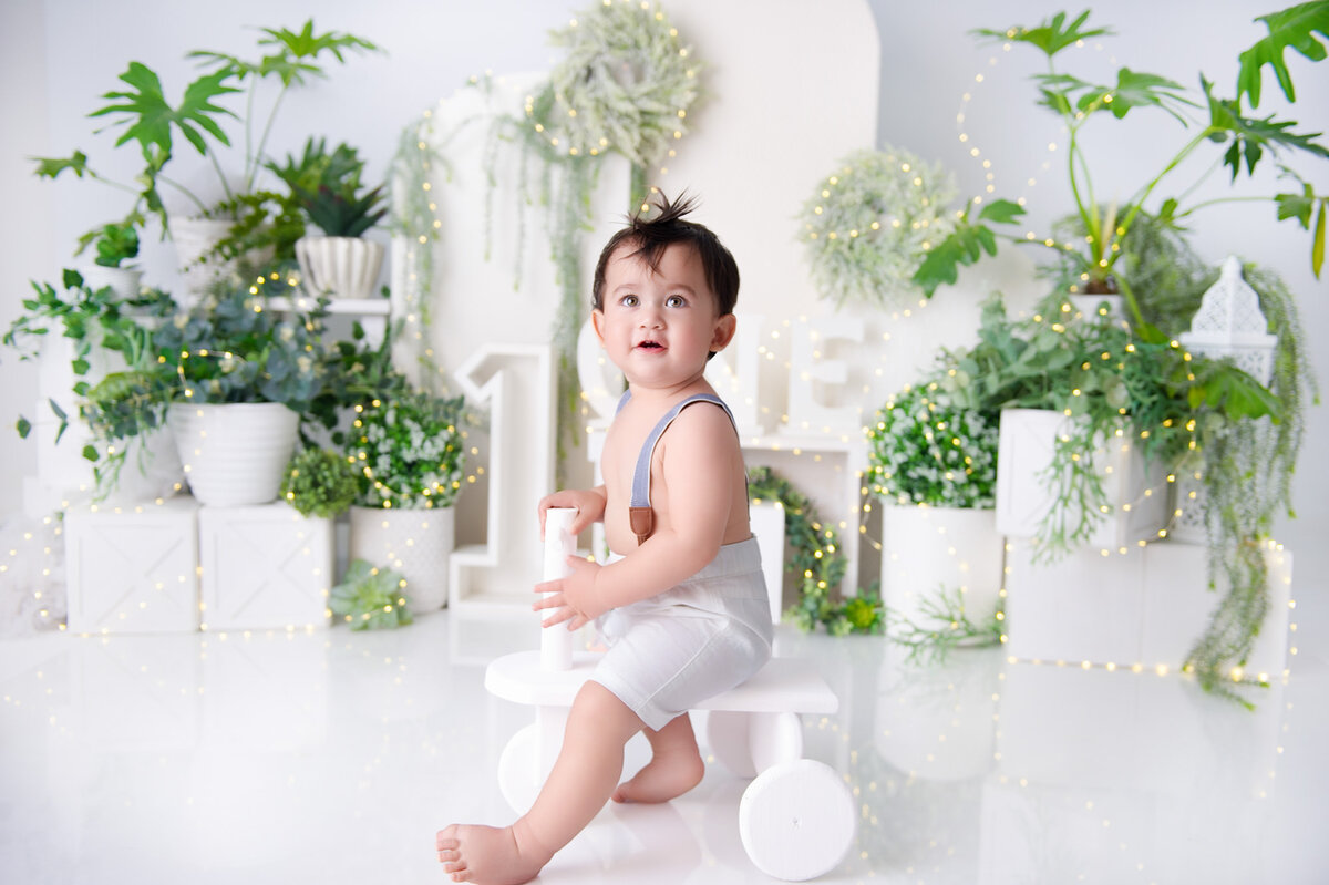 white and green cake smash boy on wood trike