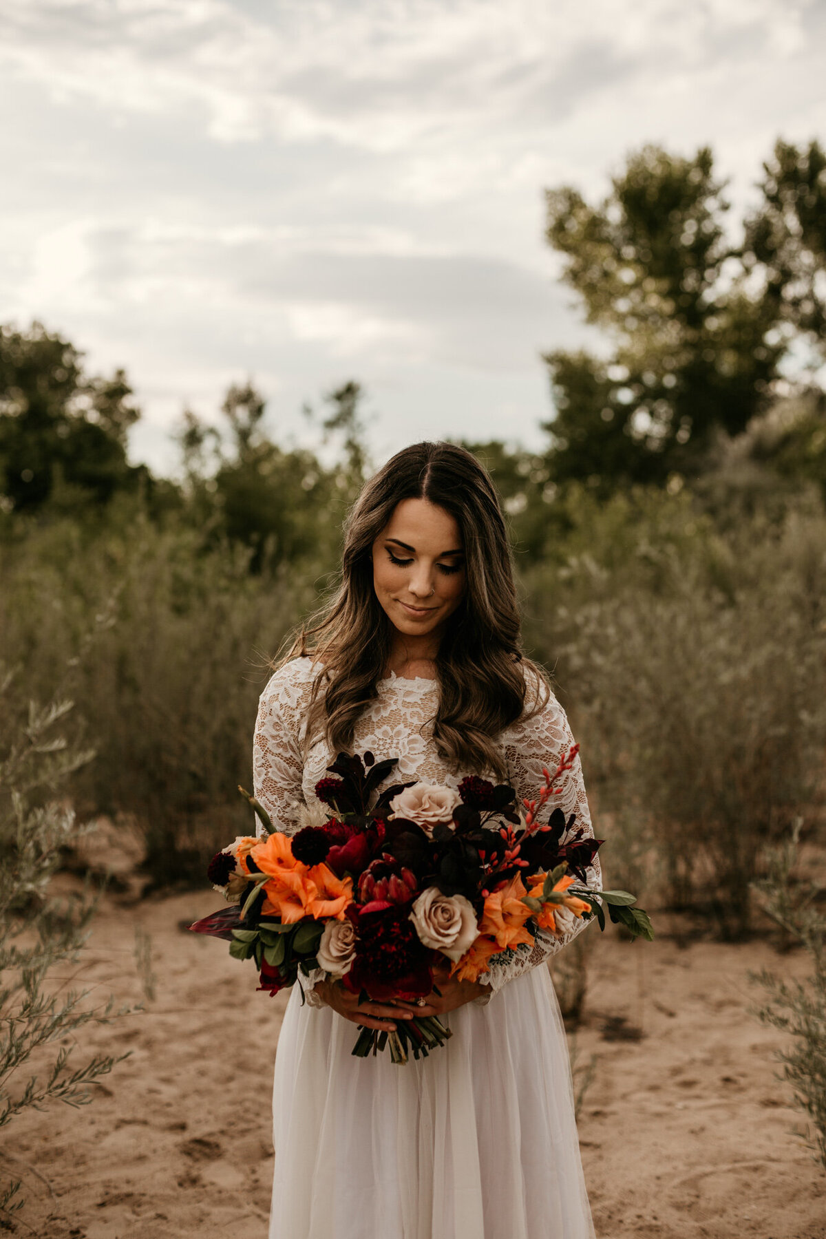 bride holding bouquet in lace wedding dress