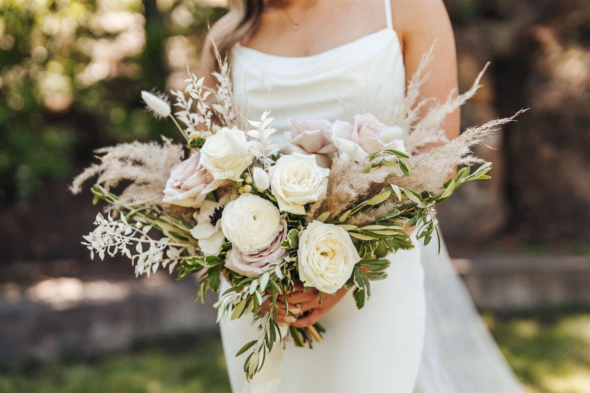 Boho feeling bridal bouquet with white roses, dried ruscus, olive foliage and pampas grass