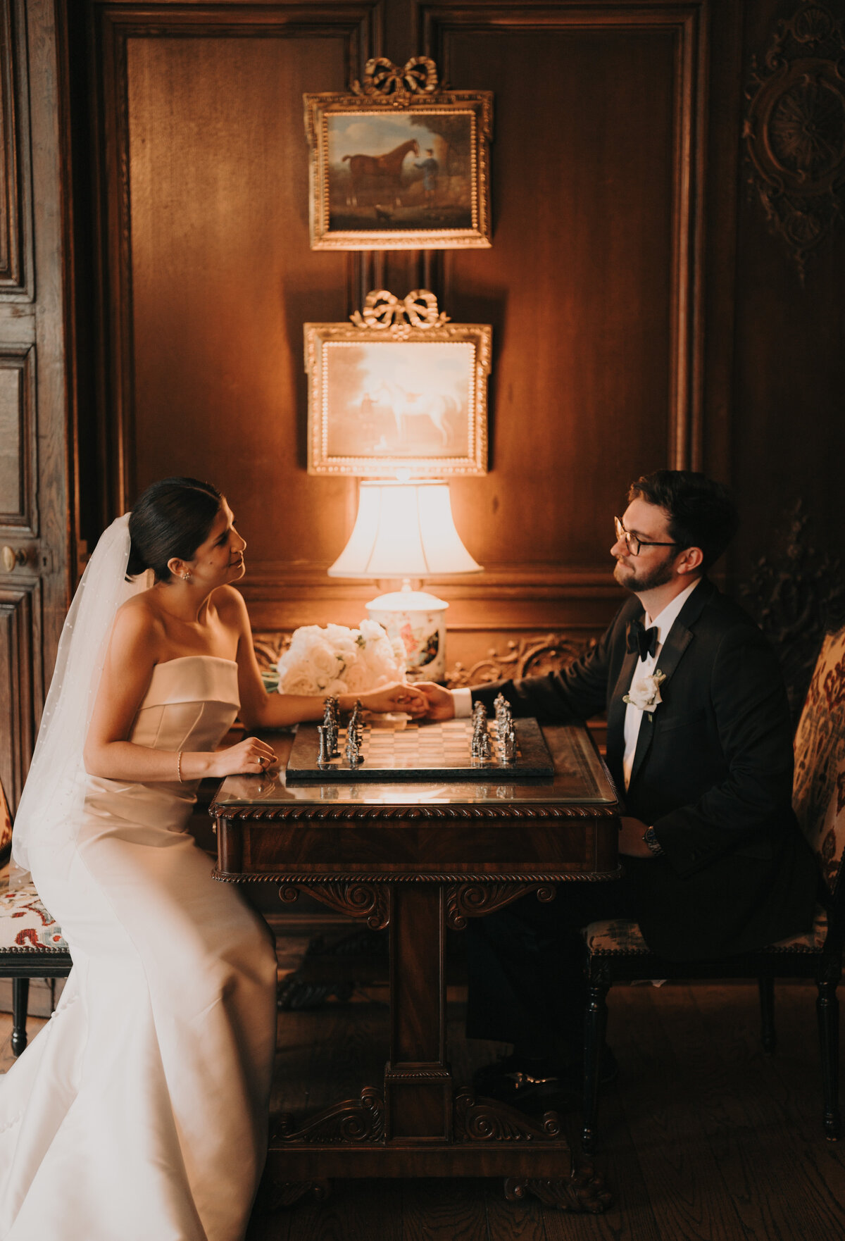bride and groom holding hands and playing chess at The Graylyn Estate