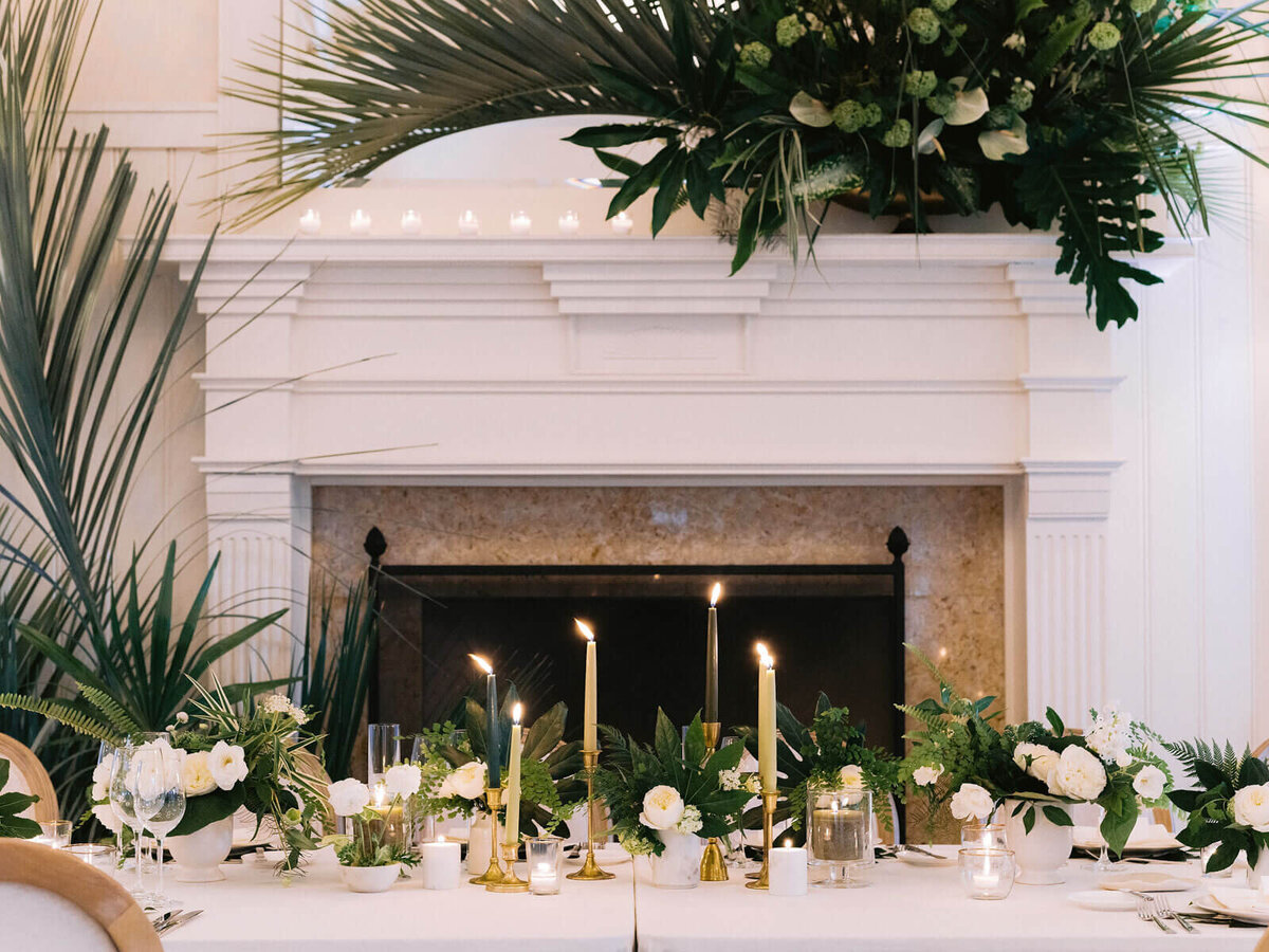A dinner table set-up with candles and white roses in Montage at Palmetto Bluff, SC. Destination Wedding Image by Jenny Fu Studio