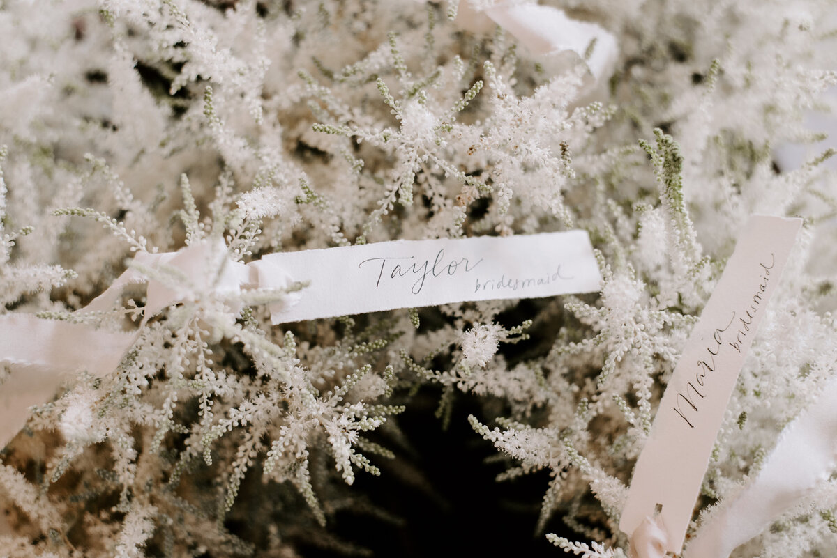 Moody photo of wedding florals and wedding party name tags.
