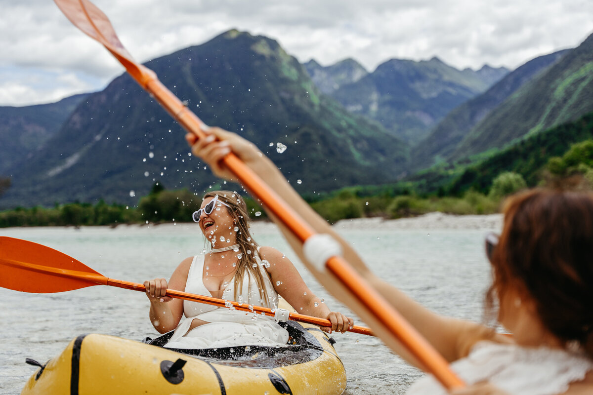 romantic couple in wedding dresses kayaking Soča River