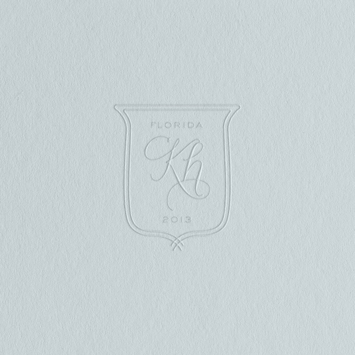 a timeless crest logo embossed on blue paper