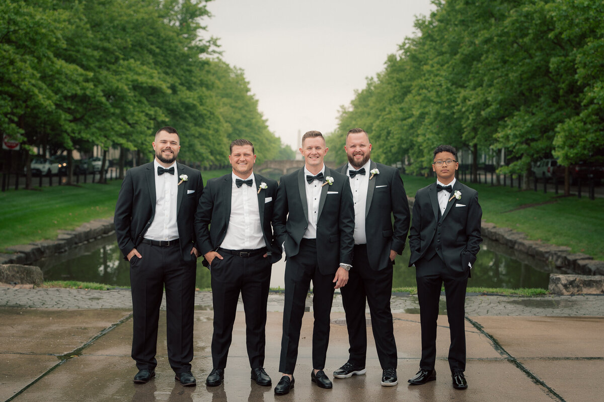 Groomsmen portrait by canal in classic black tuxedos