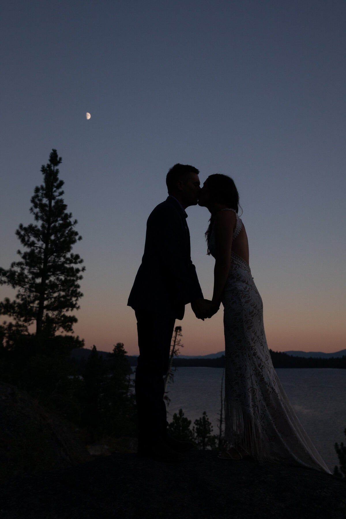 The silhouette of a bride and groom kissing