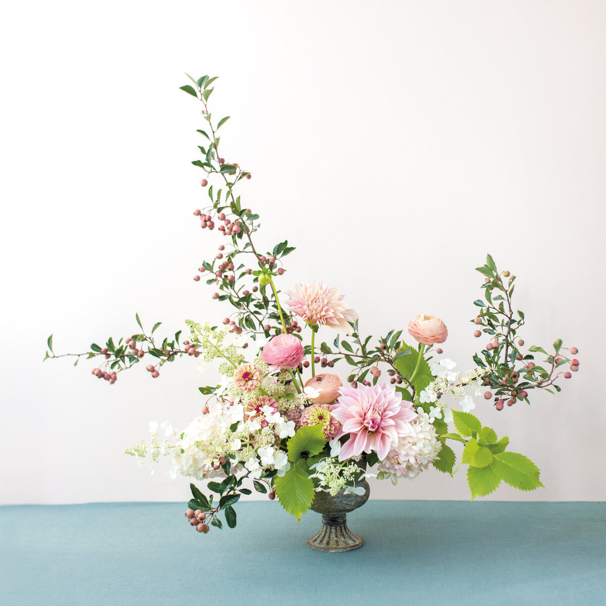 Pink flowers and lush greenery in an airy wedding arrangement.