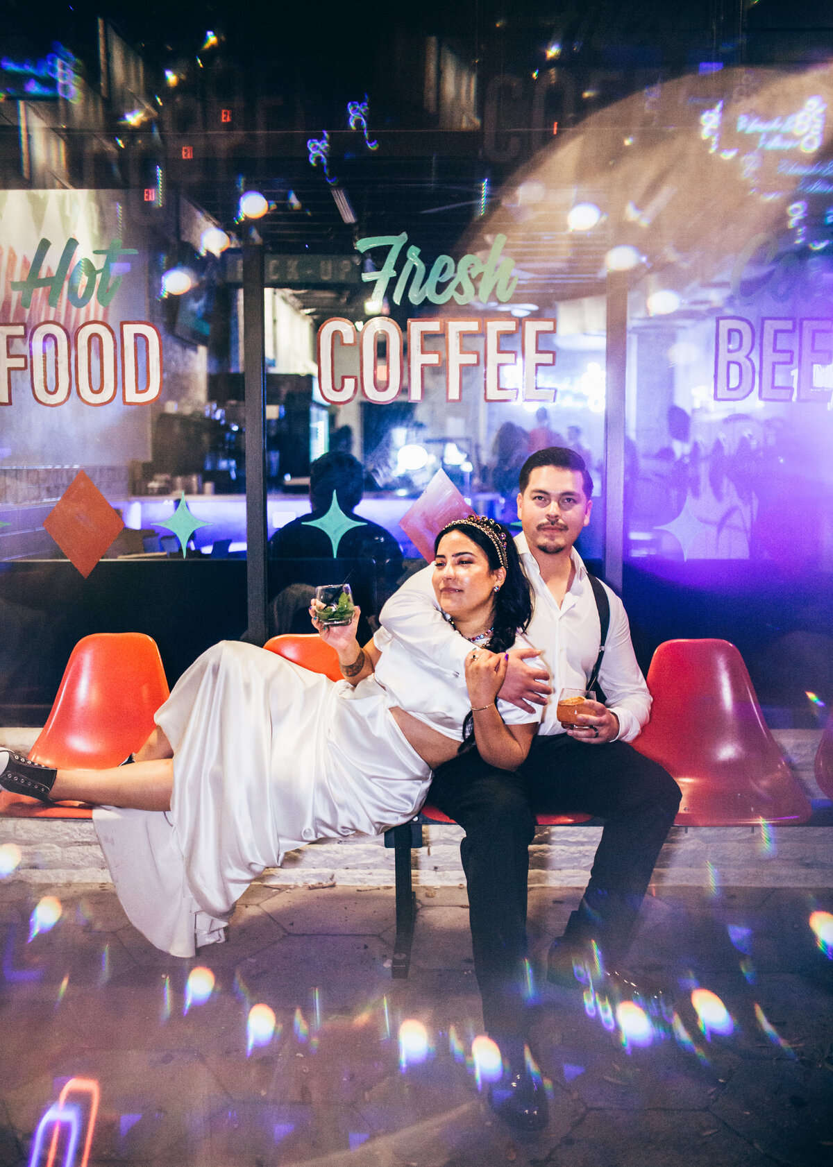 a bride and groom relaxing on a bench outside their wedding venue