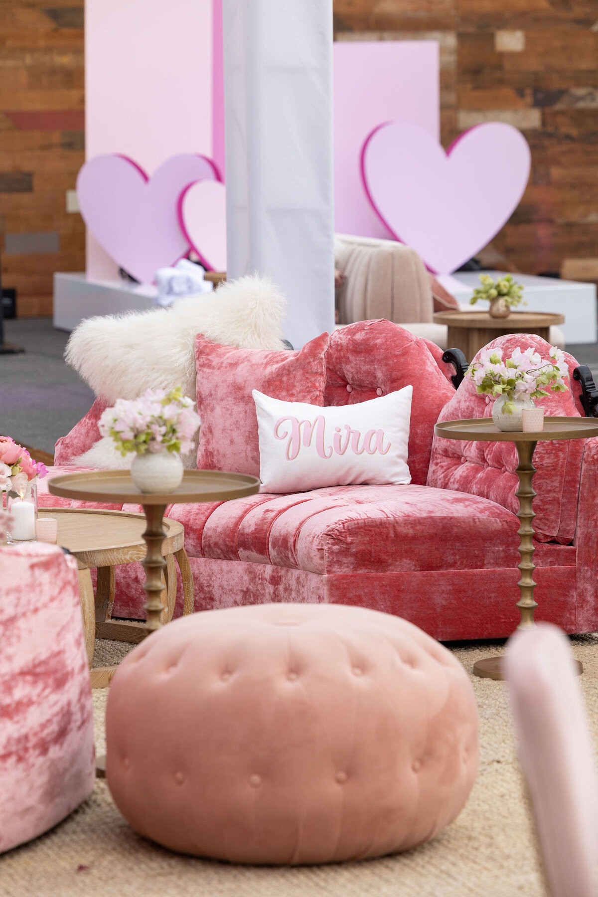 Decoration for a mitzvah using pink sofas, soft pink flowers and pink hearts