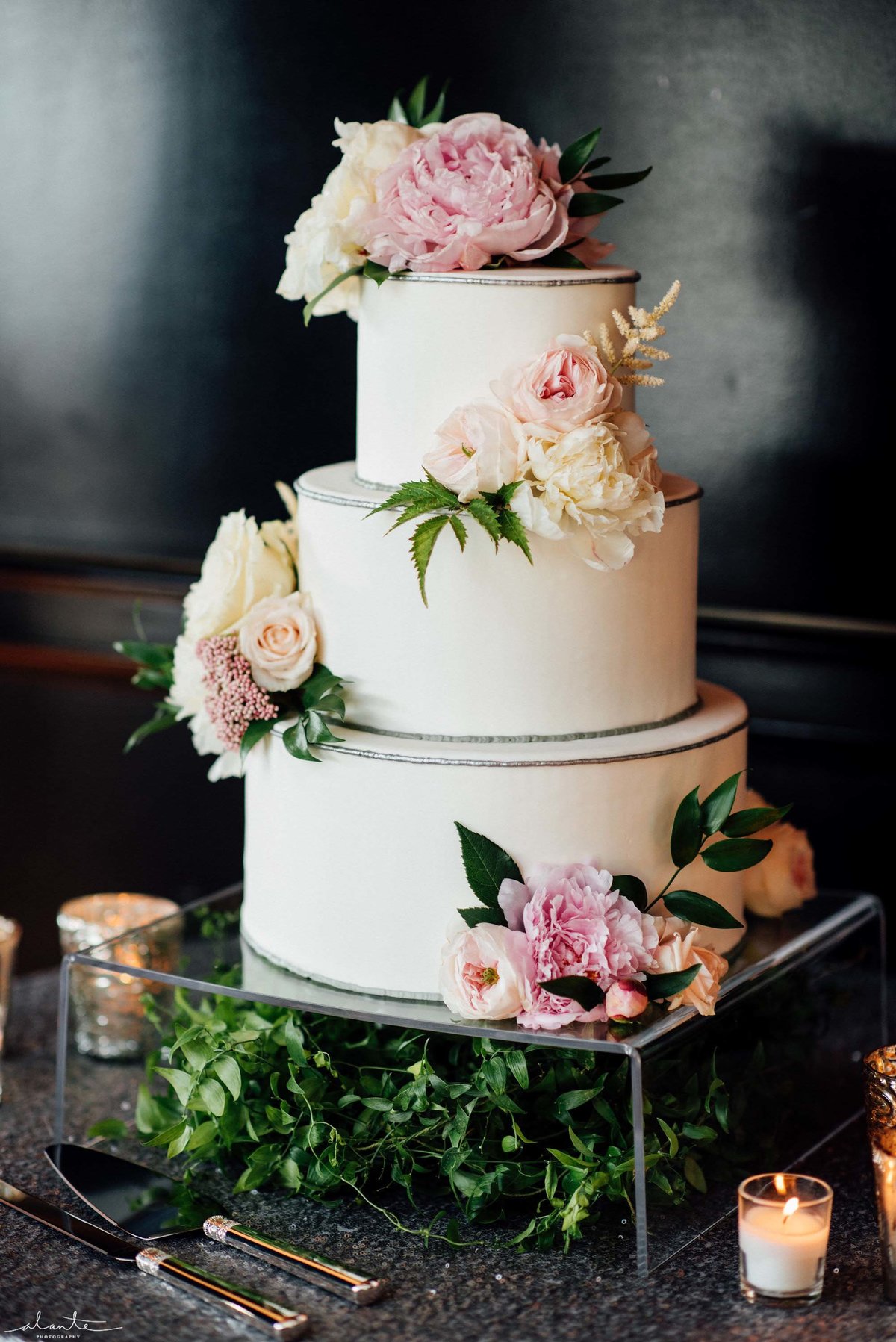 Beautiful white layer cake with peonies, astilbe and roses.