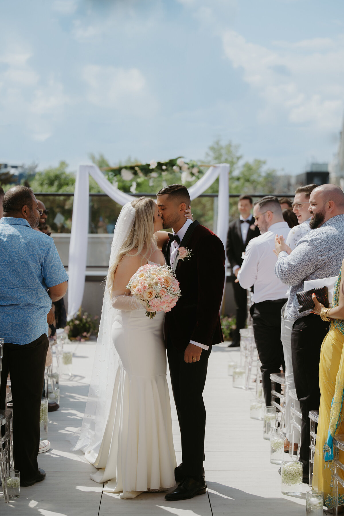 bride and groom kissing as the leave rooftop ceremony