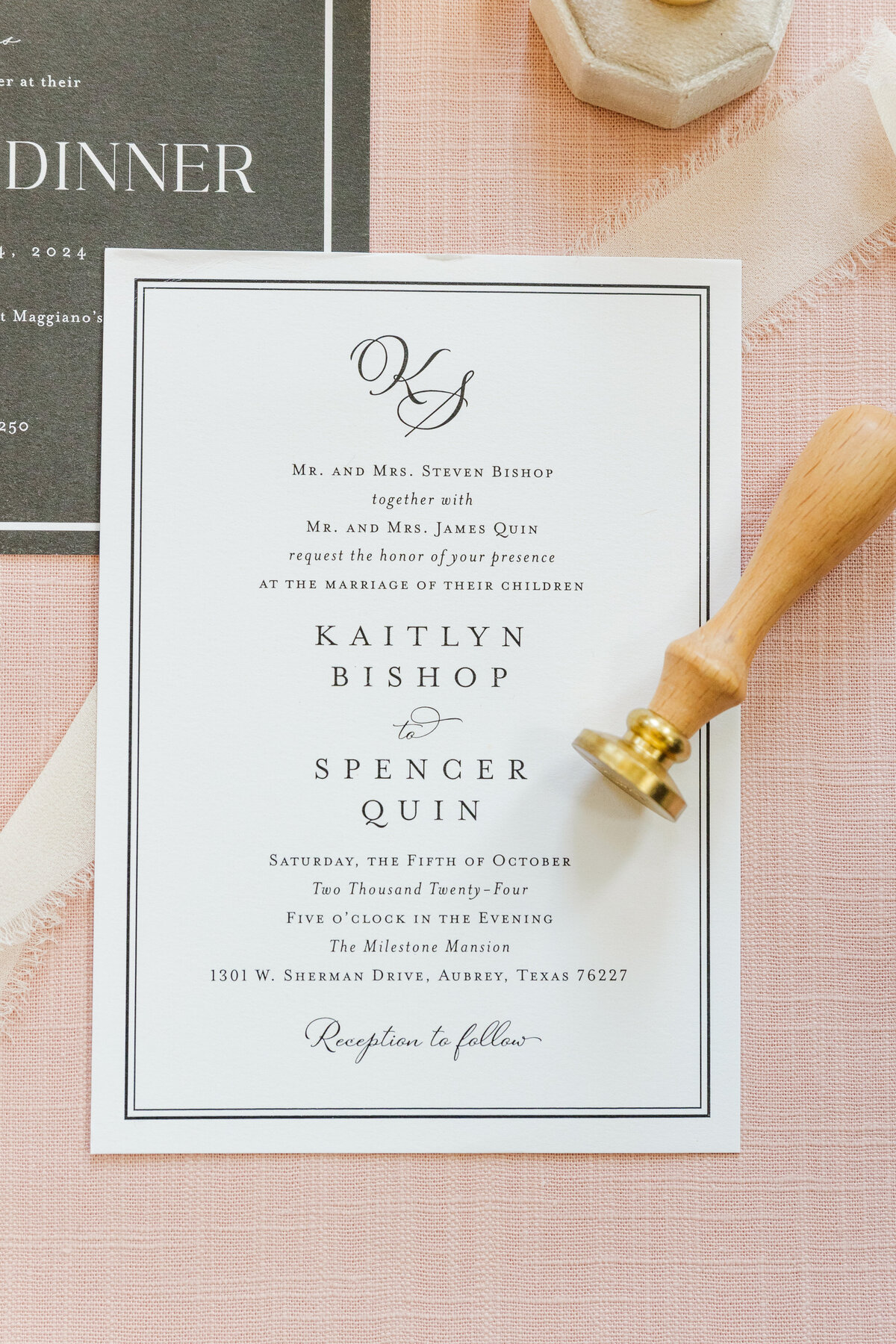 A refined wedding invitation styled on soft blush linen with silk ribbon and a brass wax seal stamp. Photographed in Aubrey, Texas, this editorial flat lay captures timeless southern wedding style with classic typography and romantic textures.