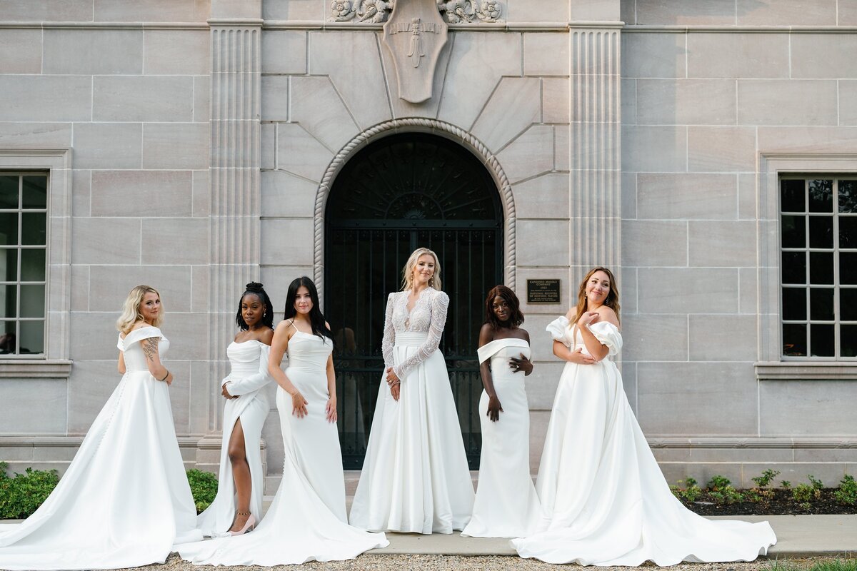 A group of women posing n wedding dresses