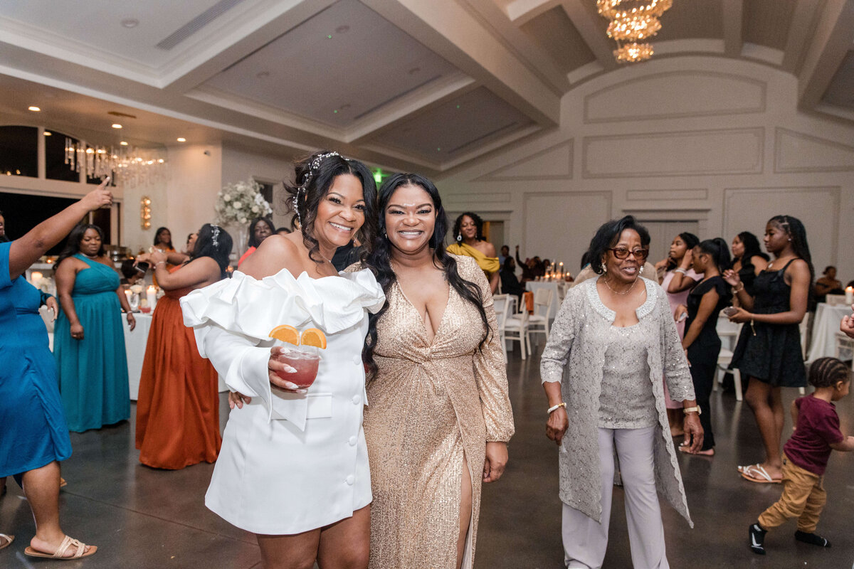 The bride smiles as she tosses her bouquet, with eager guests reaching to catch it.