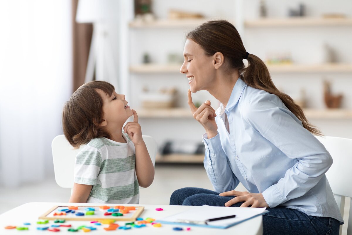 young woman speech therapist working with child