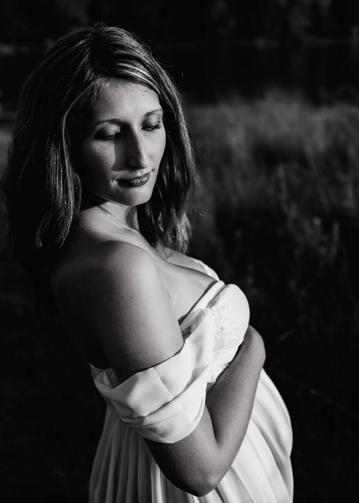 A pregnant woman poses for a black and white photo taken by a Pittsburgh maternity photographer.